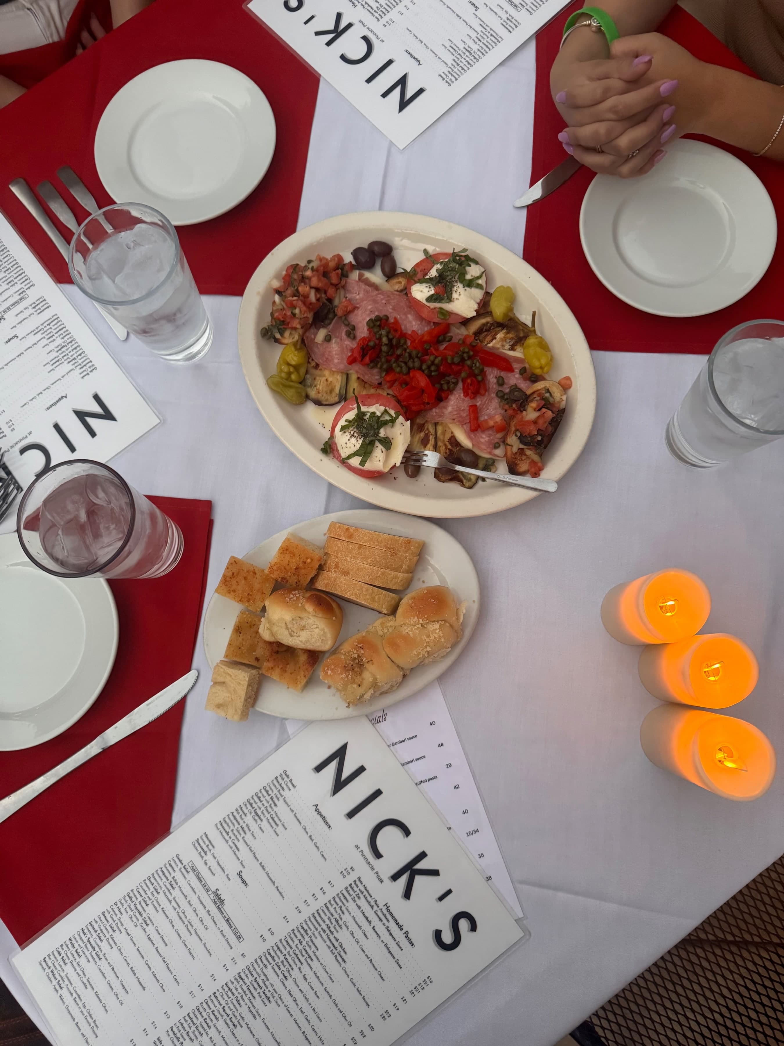Catering-style antipasto spread with house bread on a Nick's table.