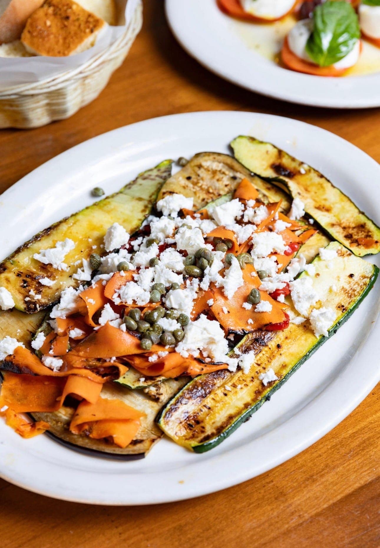 Grilled vegetables with feta and capers on a Nick's plate.