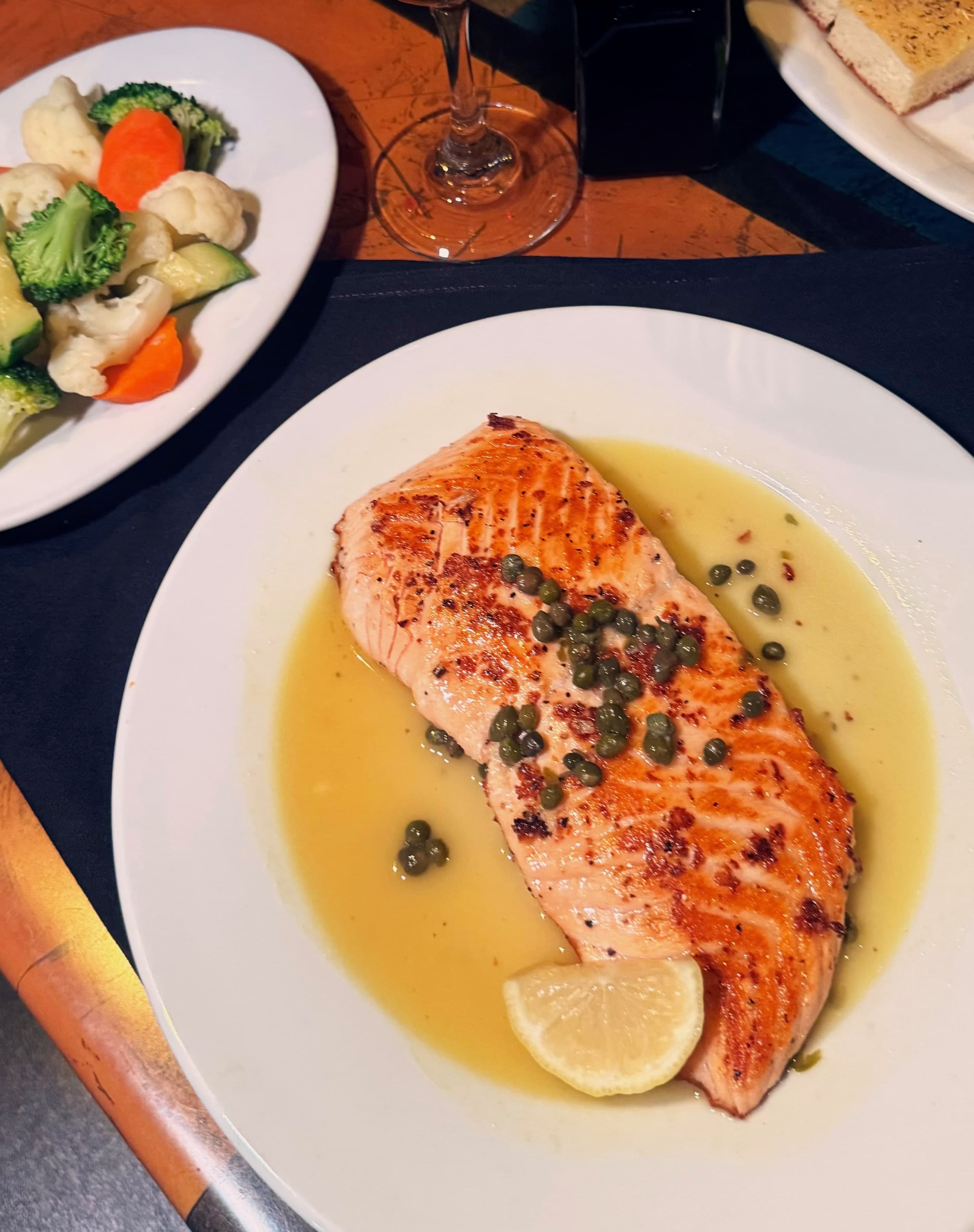 Atlantic salmon in lemon piccata sauce with capers and angel hair pasta.
