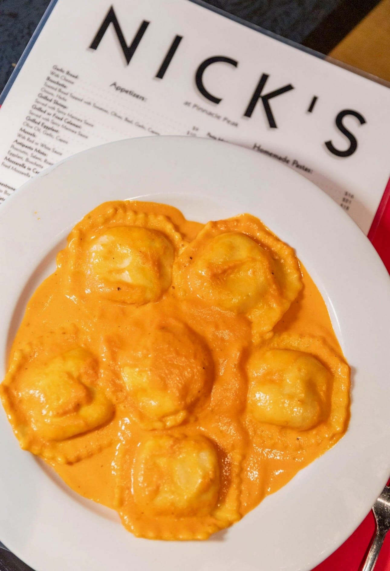 Seafood ravioli in pink sauce on a Nick's menu placemat.